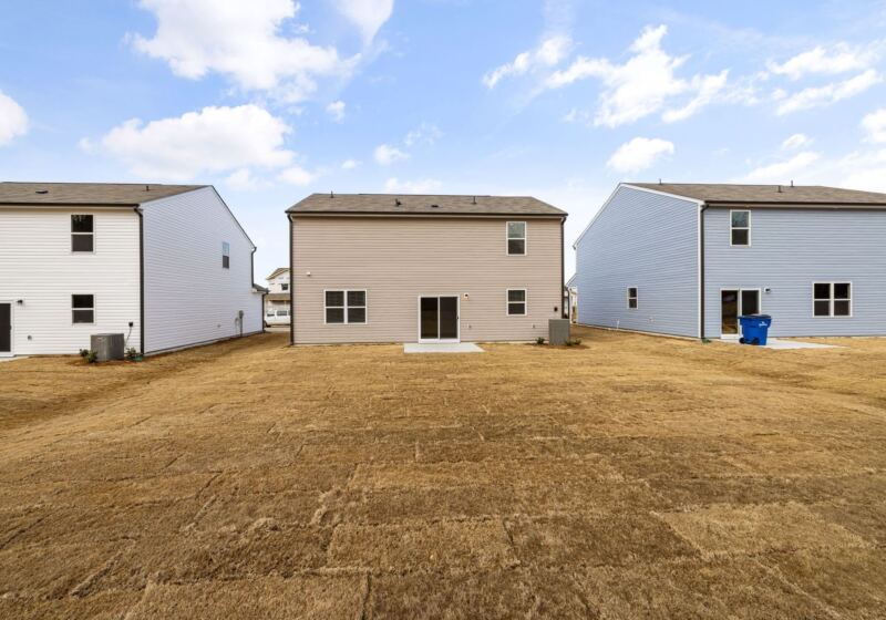 Bare dirt lot behind a new build