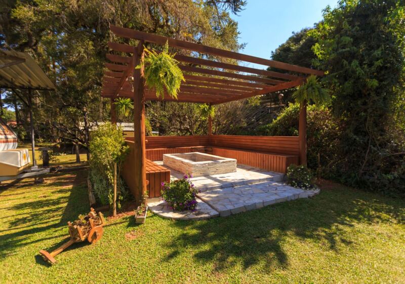 Cedar pergola over a hot tub in a landscaped backyard